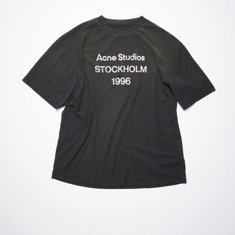 La t-shirt nera sbiadita di Acne Studios presenta un timbro del logo Acne Studios 1996 sul davanti, realizzata in misto cotone e canapa con una finitura spruzzata. Adornato con dettagli invecchiati sulla scollatura, sui polsini e sull`orlo e tagliato
