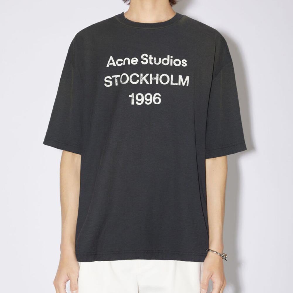 La t-shirt nera sbiadita di Acne Studios presenta un timbro del logo Acne Studios 1996 sul davanti, realizzata in misto cotone e canapa con una finitura spruzzata. Adornato con dettagli invecchiati sulla scollatura, sui polsini e sull`orlo e tagliato