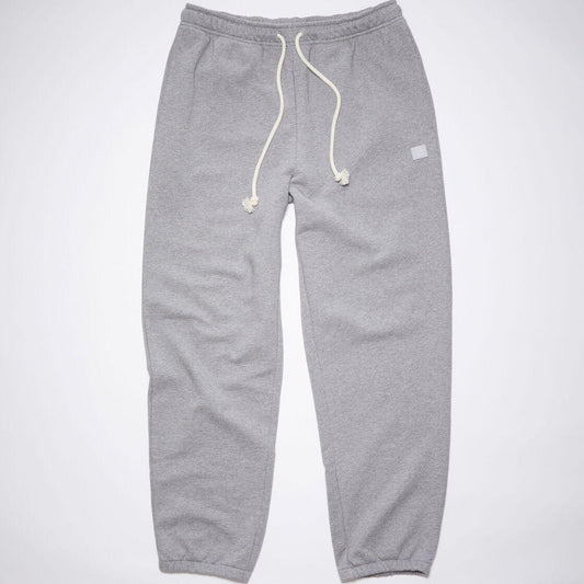 Acne Studios light grey melange fleece sweatpants feature two side pockets and a back pocket. Cut to a regular unisex fit with an elasticated waist and hem. Detailed with contrast drawstring, and complete with a face logo patch.